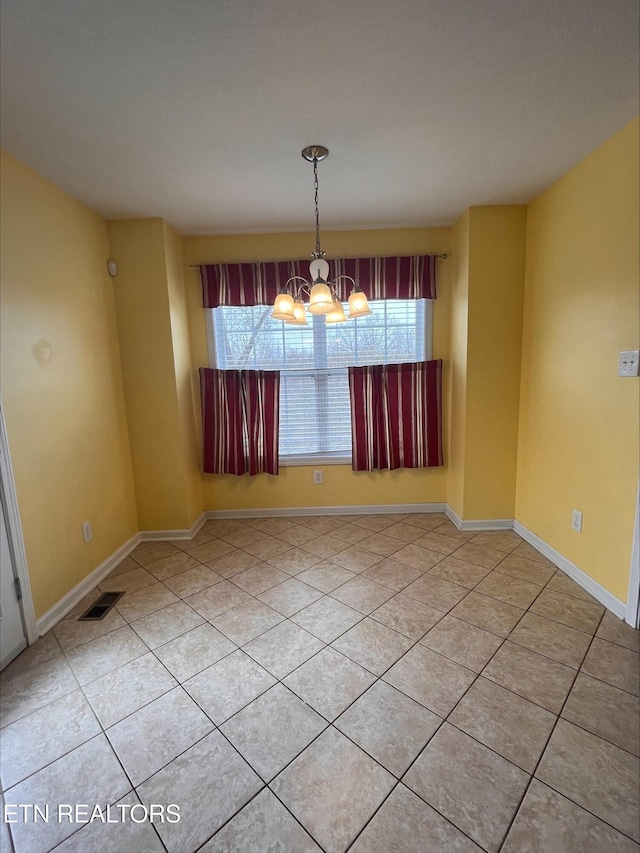 spare room featuring a notable chandelier, visible vents, plenty of natural light, and light tile patterned floors