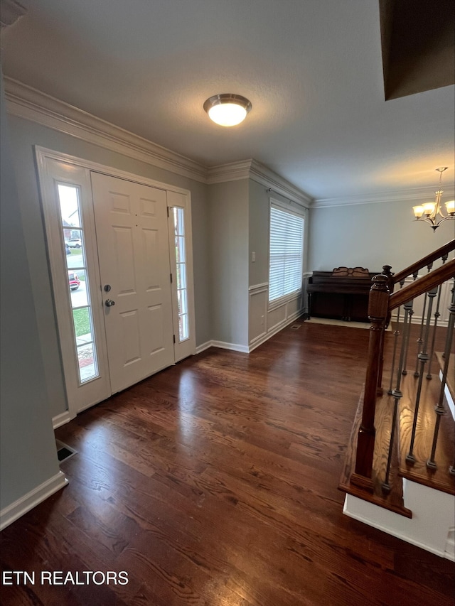 foyer featuring ornamental molding, an inviting chandelier, and wood finished floors