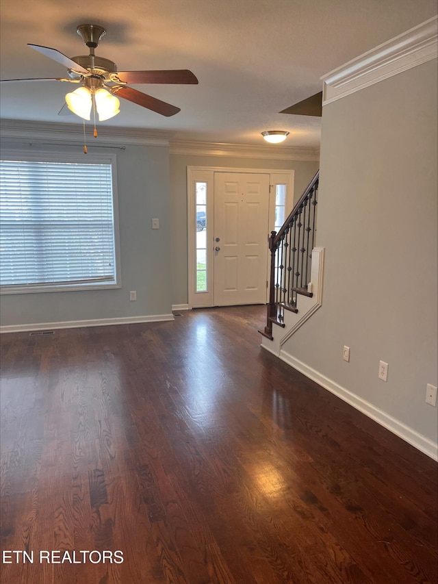 entryway featuring dark wood-type flooring, stairway, crown molding, baseboards, and ceiling fan