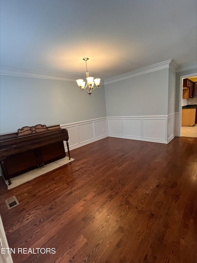 interior space with a notable chandelier, visible vents, dark wood-style flooring, and ornamental molding