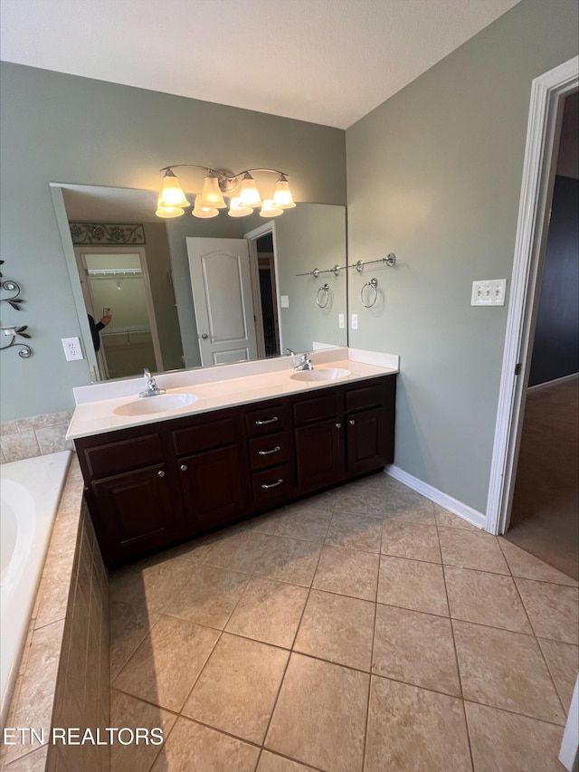 full bath with a sink, a garden tub, double vanity, and tile patterned floors