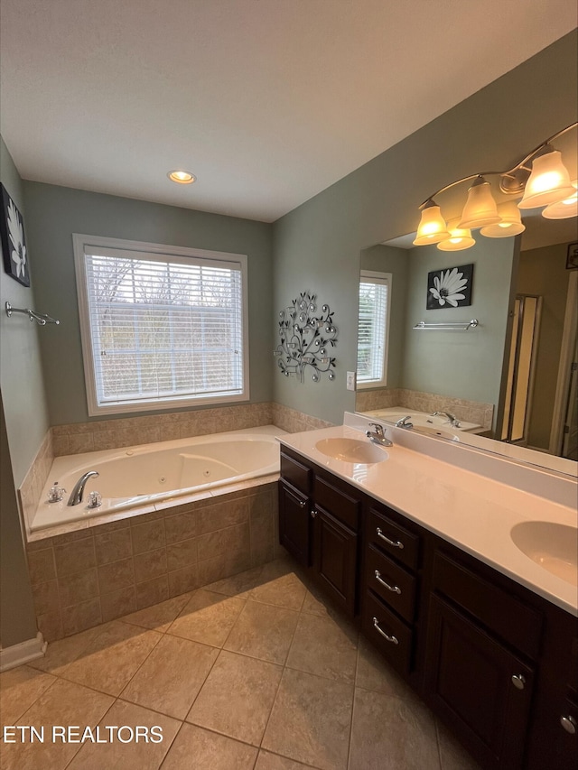 bathroom featuring a sink, a tub with jets, double vanity, and tile patterned flooring