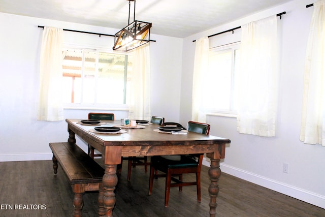 dining space featuring dark wood finished floors, plenty of natural light, and baseboards