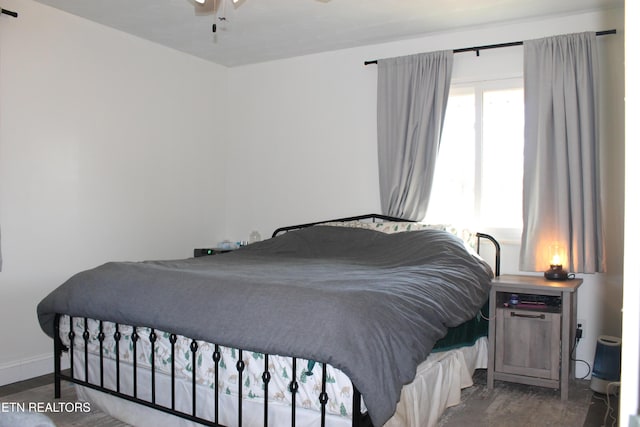 bedroom with baseboards, a ceiling fan, and dark wood-style flooring