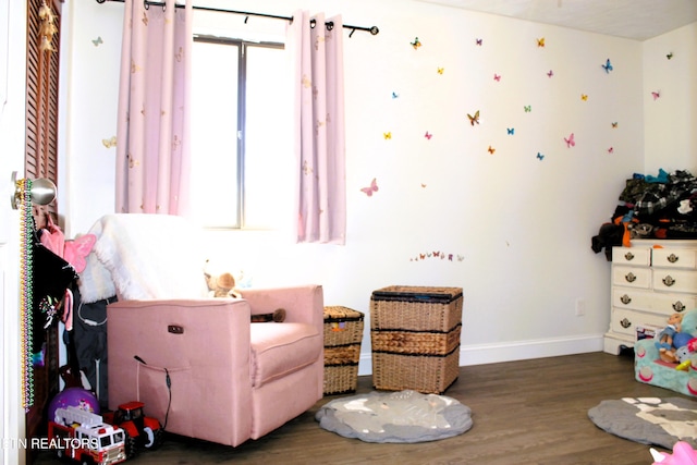 sitting room with baseboards and wood finished floors