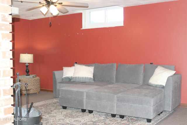 carpeted living area featuring baseboards and ceiling fan