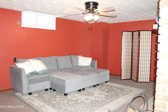 living area featuring baseboards and ceiling fan