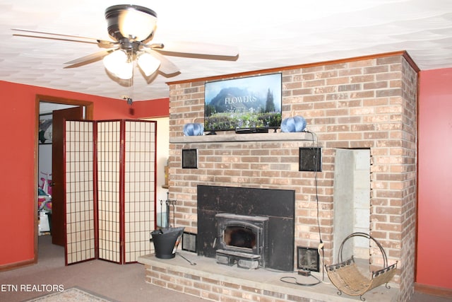 living room featuring carpet flooring, a wood stove, and ceiling fan