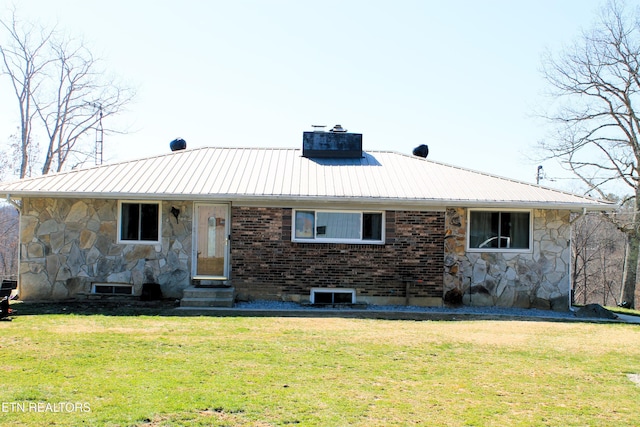 ranch-style home featuring metal roof, a front yard, and entry steps