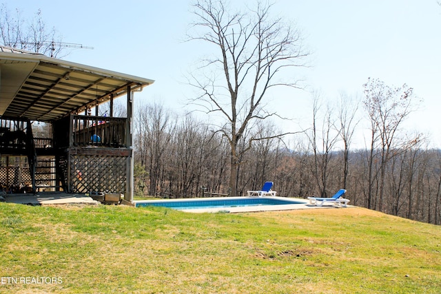 view of yard featuring stairway, an outdoor pool, a wooden deck, and a view of trees