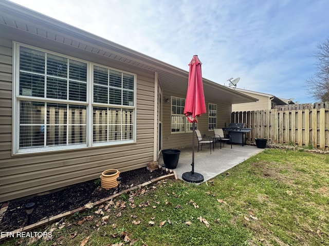 exterior space with a patio area, a lawn, and fence