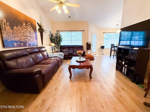 living room with wood finished floors, a ceiling fan, and vaulted ceiling