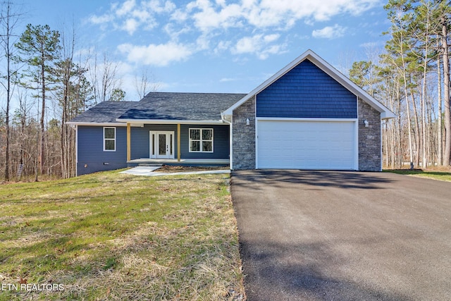 view of front of house with a front lawn, french doors, driveway, stone siding, and an attached garage