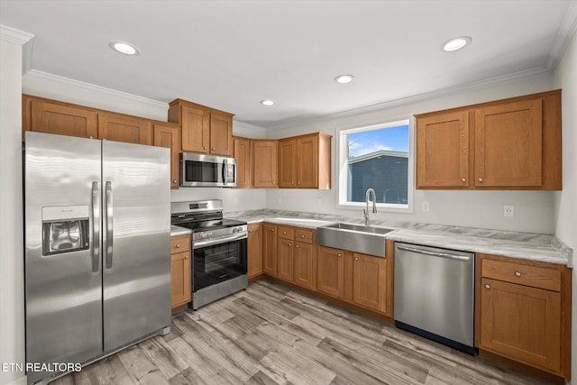 1600 Anna Maria Ln, Cookeville, TN 38501 - kitchen featuring appliances with stainless steel finishes, a sink, light countertops, crown molding, and light wood finished floors