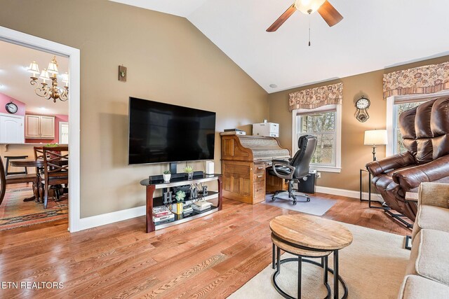 office with ceiling fan with notable chandelier, baseboards, lofted ceiling, and wood finished floors