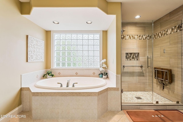 bathroom featuring tile patterned flooring, recessed lighting, a shower stall, and a garden tub