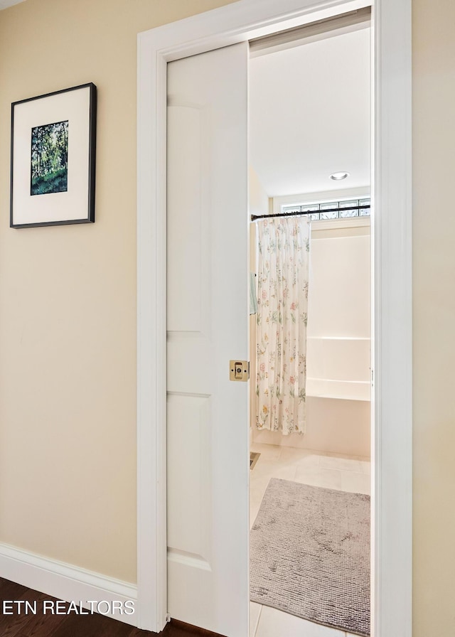 full bath with tile patterned flooring and baseboards