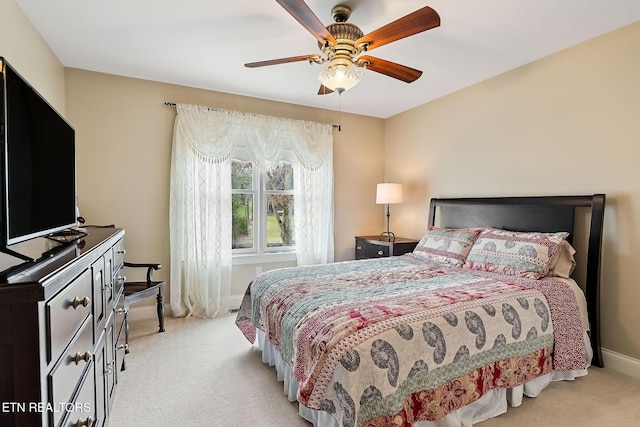 bedroom with light colored carpet, baseboards, and ceiling fan