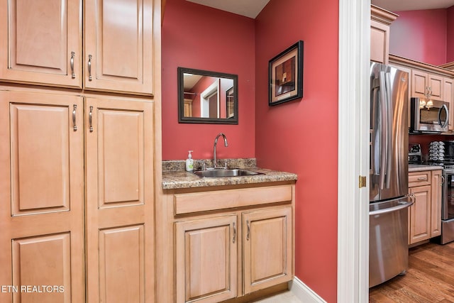 bathroom featuring a sink, baseboards, and wood finished floors