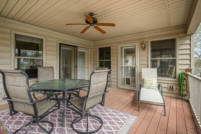 wooden terrace with outdoor dining space and a ceiling fan