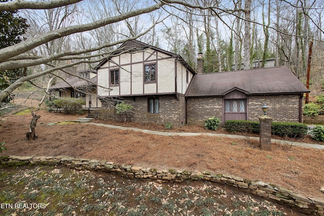 tudor house with brick siding and a shingled roof