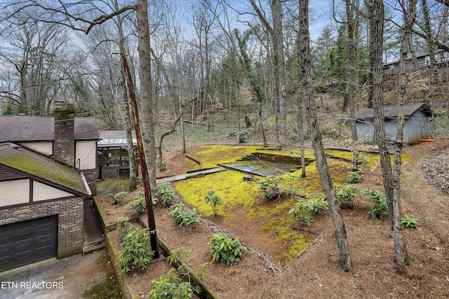 view of yard with an outbuilding, a garden, and a garage