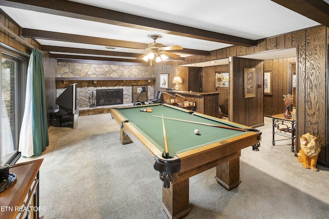 recreation room featuring billiards, carpet floors, beam ceiling, a stone fireplace, and wood walls