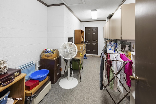 recreation room featuring concrete block wall and crown molding