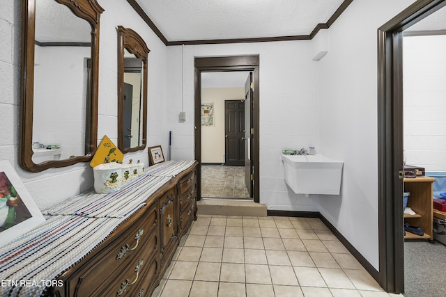 bathroom with tile patterned flooring, baseboards, vanity, ornamental molding, and a textured ceiling