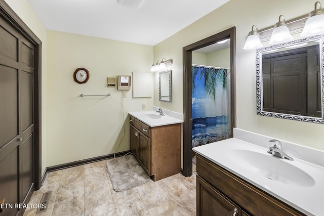 bathroom with two vanities, baseboards, and a sink