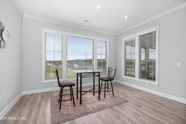 dining area with ornamental molding, baseboards, and wood finished floors