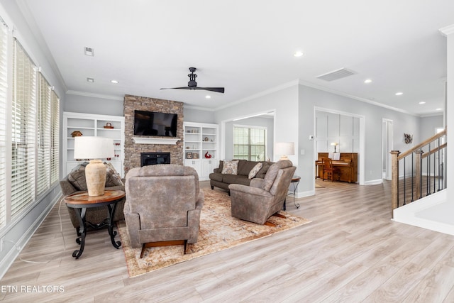 living room with visible vents, a ceiling fan, wood finished floors, and a fireplace