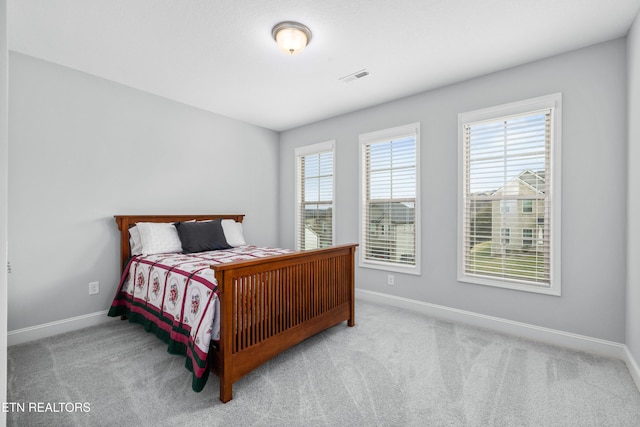 carpeted bedroom with visible vents and baseboards