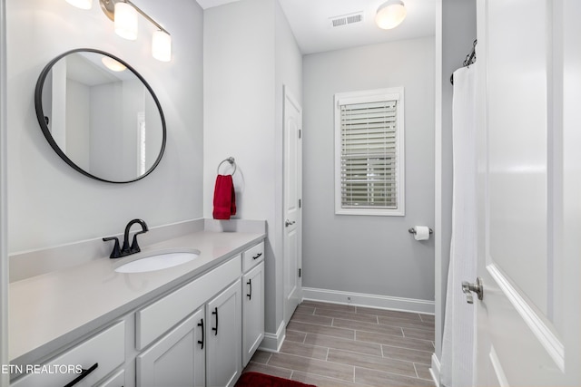 full bathroom with visible vents, baseboards, wood tiled floor, and vanity