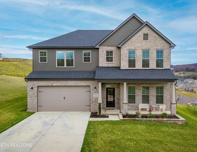 craftsman-style home with roof with shingles, an attached garage, covered porch, a front lawn, and concrete driveway