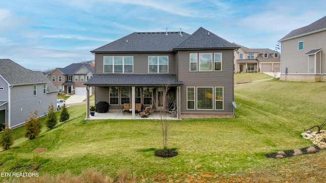 back of property with a patio area, a residential view, a yard, and roof with shingles