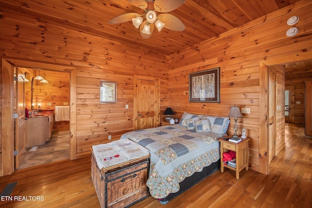 bedroom with wood finished floors, visible vents, radiator heating unit, a sink, and wooden ceiling