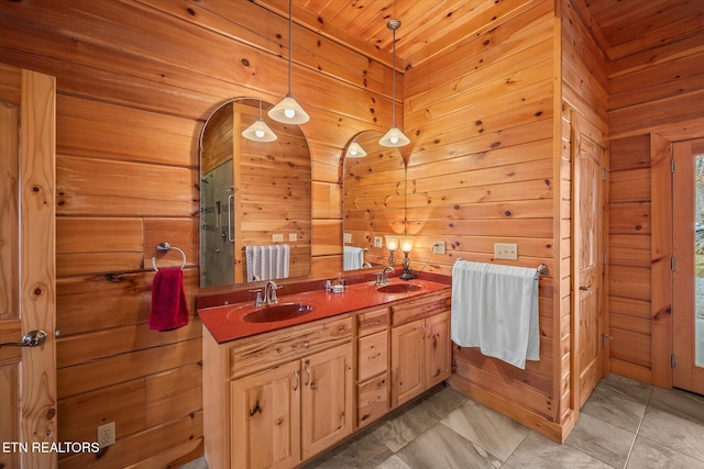 bathroom with double vanity, wood walls, a shower with shower door, and a sink