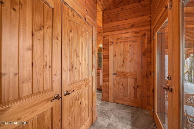 hallway featuring wooden walls