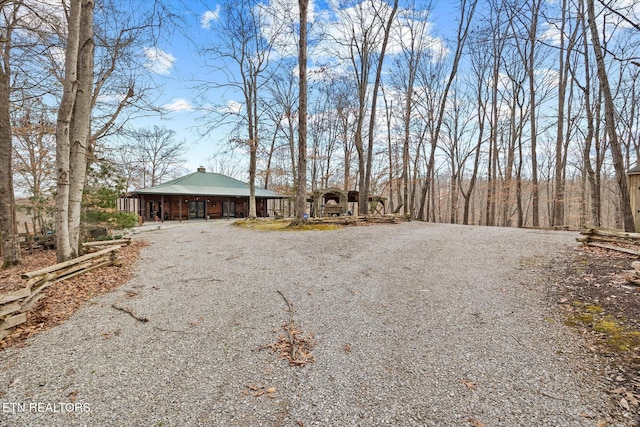 view of front of property featuring a porch and gravel driveway