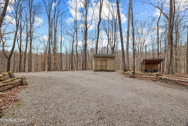 view of yard with an outbuilding, driveway, and a storage shed