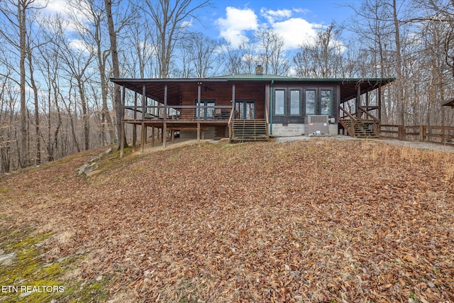 rear view of house with a chimney and ceiling fan