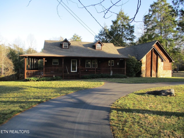 view of front of house with stone siding, a porch, and a front yard