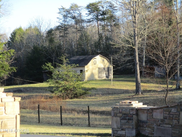 view of yard with a shed, an outdoor structure, and fence