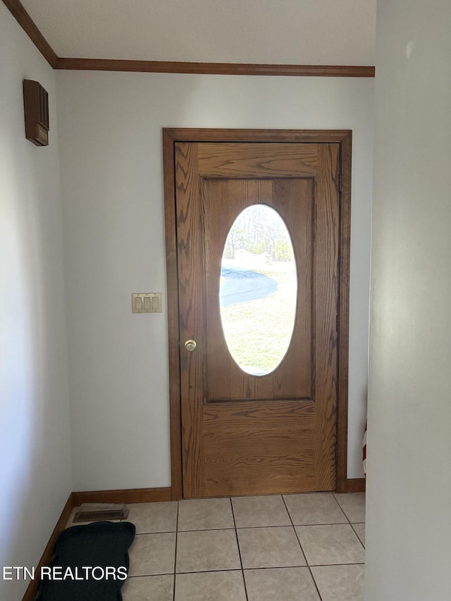 entryway featuring light tile patterned flooring, visible vents, baseboards, and ornamental molding