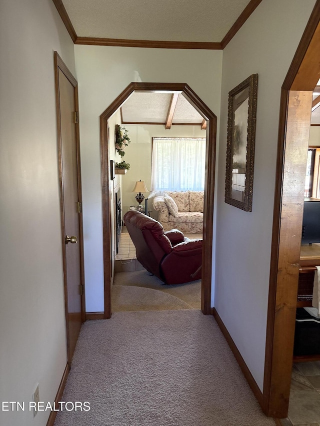 hallway featuring crown molding, carpet, and baseboards