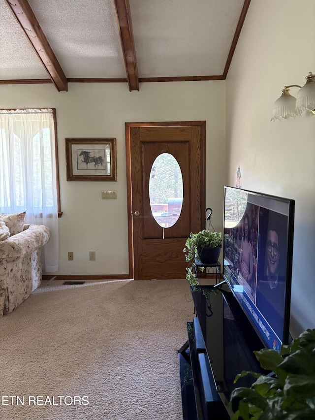 entryway featuring carpet flooring, beam ceiling, plenty of natural light, and a textured ceiling