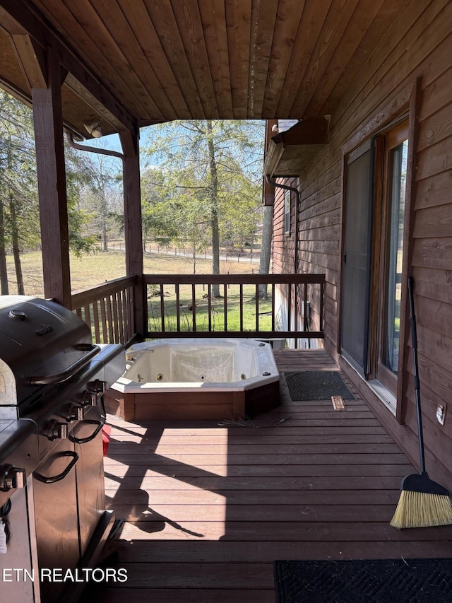 wooden terrace featuring hot tub deck surround