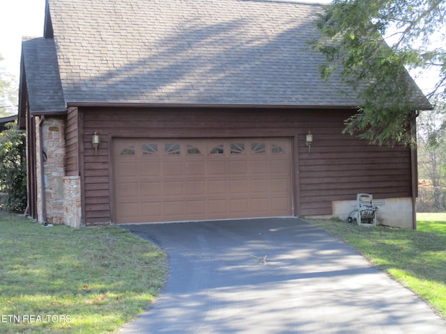 view of home's exterior with a garage, stone siding, and roof with shingles