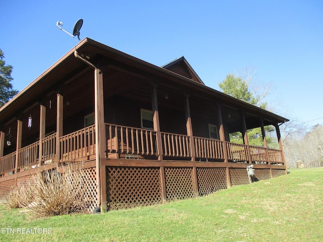 view of side of property featuring covered porch and a yard